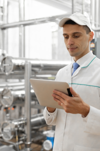 Homme avec casquette et blouson blanc contrôlant une machine à distance